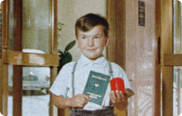 Ein historisches Foto eines Kindes mit Sparbuch in der Hand